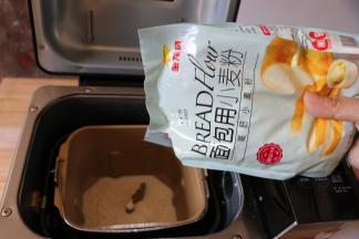 将牛奶倒入面包机的面包桶中，盐、白砂糖对角放，倒入金龙鱼面包用小麦粉，这个粉采用100%进口小麦为原料，麦香浓郁，制作过程中易膨胀易拉丝，吸水性也好，面粉质量稳定性较好，成品香软可口；