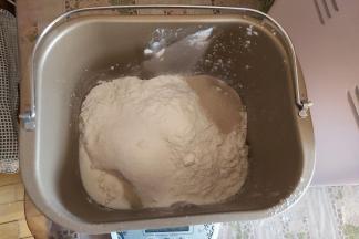 然后把面粉、糖、酵母、盐也放入桶内。（盐、糖、酵母要防止不同的角落哟）
