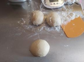 醒好面团后取出一份排气，另两块仍然用保鲜膜盖好。