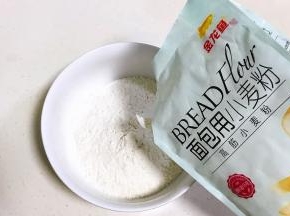大碗内倒入金龙鱼面包用小麦粉和盐，混合拌匀。