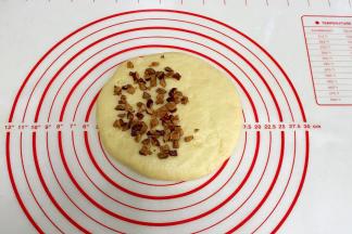 把揉好的面团擀成圆皮状，放上事先切好的1/2红枣碎。