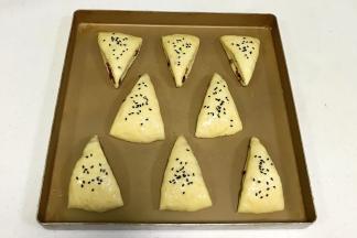 司康摆入不粘烤盘，表面刷上全蛋液，撒上黑芝麻。