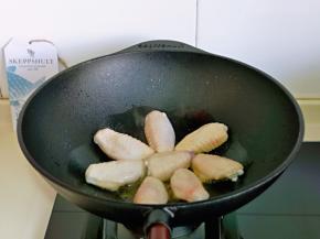 待油热后摆入鸡翅，小火煎至两面金黄。