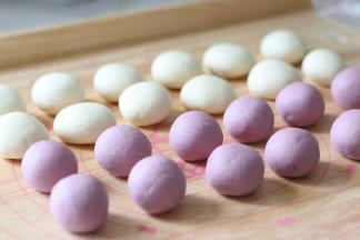 把他们都在案板上揉一揉，揉成团，紫色的可以搓圆一些，白色的搓圆后压扁。
