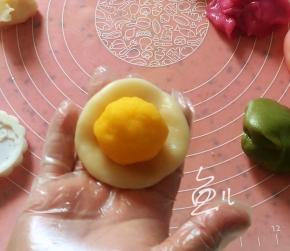 分成25克一个小面团，搓成小圆球压扁，放上奶黄馅
