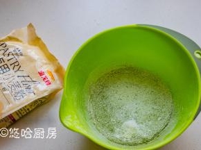 加入清水搅匀，筛入低粉、抹茶粉。蛋糕粉最好要过筛，一是避免面粉结块，二是让面粉蓬松，蛋糕体口感松软。金龙鱼蛋糕粉筋性低，做出的蛋糕口感松软。