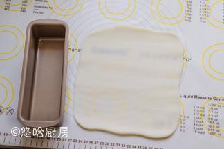 把水晶皮平均分成2块，案板上撒一点冰皮粉，将水晶皮擀开和旁边的磅蛋糕模具一样长。