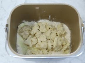 主面团的材料按液体到粉类的顺序放入面包机桶内，中种面团撕成小块。