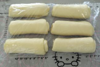 取一小份面团，擀成牛舌状，翻面，从上往下卷好，盖保鲜膜松弛15分钟。