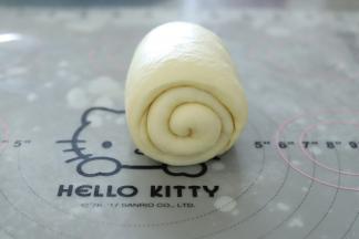 再次将面团擀成牛舌状，从上往下卷。