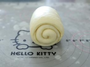 再次将面团擀成牛舌状，从上往下卷。