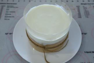 蛋糕用12厘米的透明围边围好，做好的淡奶油倒在蛋糕上。