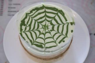 抹茶液在淡奶油上从中间开始画圆圈，然后用牙签画好花纹。