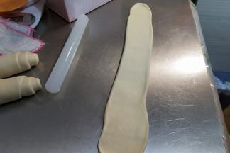 然后不要松弛，直接取一个擀卷的面团，再次轻轻的擀长，长度大约是50厘米。