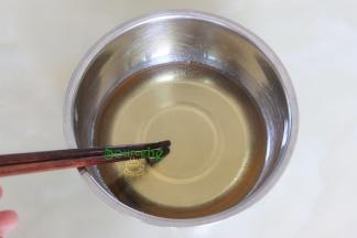 月饼皮的制作：转换糖浆倒入碗里，加枧水、花生油搅拌均匀。