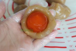 把馅蛋黄放入莲蓉馅，包裹好。