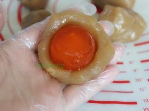 把馅蛋黄放入莲蓉馅，包裹好。
