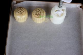 月饼模具内侧撒一些炒熟的糯米粉，防止粘再月饼模具上，然后把做好的月饼面团放入月饼模具里压出月饼形状。