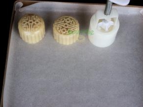 月饼模具内侧撒一些炒熟的糯米粉，防止粘再月饼模具上，然后把做好的月饼面团放入月饼模具里压出月饼形状。