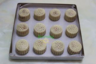 把做的月饼均匀放在烤盘上，并用碰水的瓶子拿在远处轻轻喷一层水。为了月饼颜色好看的，可以再月饼表面涂层鸡蛋液。