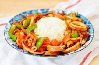 将炒好的鱿鱼连着酱汁一起淋在米饭周围，香味浓郁的鱿鱼饭就做好啦