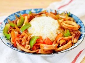 将炒好的鱿鱼连着酱汁一起淋在米饭周围，香味浓郁的鱿鱼饭就做好啦