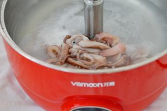 米饭蒸熟后将漉网跟米饭一起拿出，锅洗干净放上适量的清水大火煮开，之后将切好的鱿鱼放进去煮2分钟