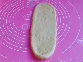 取一块面团，用擀面杖擀长舌状，由上往下卷起来，依次卷好。