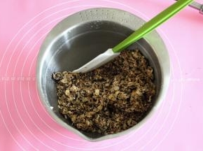 用刮刀翻拌均匀，成团。麦片的吸水性略有不同，水量可以略微调整一下，拌匀的材料能成团，带点粘性，但是不是那种湿哒哒的。