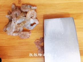 然后用厨房纸巾吸干水分，这样虾肉吃起来会更脆爽，这一步可千万不能省略哦，用刀把虾仁拍扁，把虾肠和虾线挑出