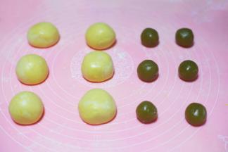 面团分成6份揉圆后压扁，莲蓉馅搓成6个圆球，