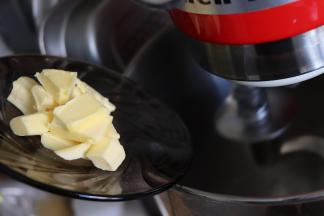 揉成光滑的团之后放入黄油，继续揉面。面团会又变得出现一些小块，继续揉。