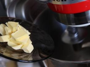 揉成光滑的团之后放入黄油，继续揉面。面团会又变得出现一些小块，继续揉。