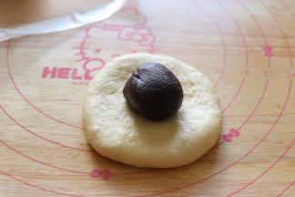 取一个用手压扁，或者用擀面杖擀成圆片，放入豆沙馅。包起来。所有的都这样操作，我包了4个豆沙的4个蔓越莓的。