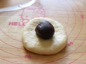 取一个用手压扁，或者用擀面杖擀成圆片，放入豆沙馅。包起来。所有的都这样操作，我包了4个豆沙的4个蔓越莓的。