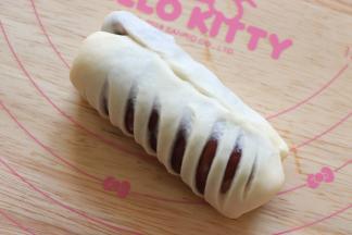 再对折，把边捏紧，就形成了一个，圆柱形的面包生坯。