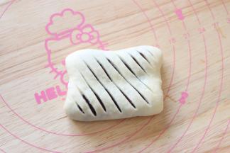 翻过来用刀片斜着割开，切割刀出现馅料就可以了，不用太深。