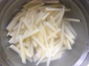 然后将土豆放入清水中冲洗2遍，将表面的淀粉冲洗干净；