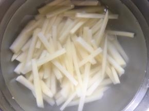然后将土豆放入清水中冲洗2遍，将表面的淀粉冲洗干净；