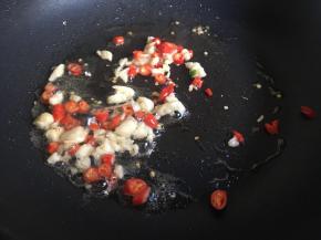 起锅倒入日常差不多的油，油热倒入小米辣、蒜末，不停煸炒爆香；