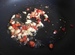起锅倒入日常差不多的油，油热倒入小米辣、蒜末，不停煸炒爆香；
