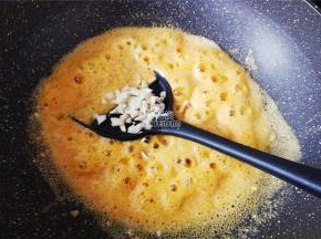 再把蒜瓣去皮切成小粒翻炒，炒制出香味来。