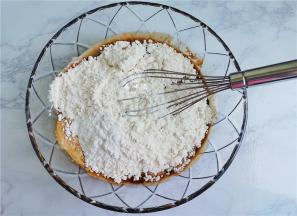 接着把低筋面粉和泡打粉倒入红糖水中。