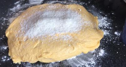 取出发酵好的面团，放在撒有干粉的案台上，加入适量椰蓉