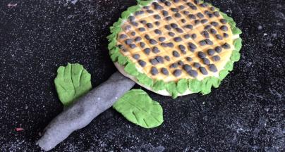 再用绿色面团，做几片绿叶，交叉粘在树杆上