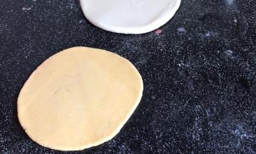 再把黄面团擀成比白面团小一圈的饼