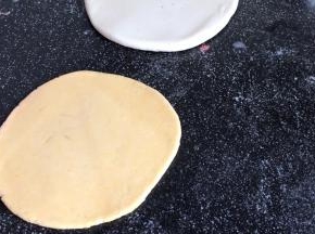 再把黄面团擀成比白面团小一圈的饼