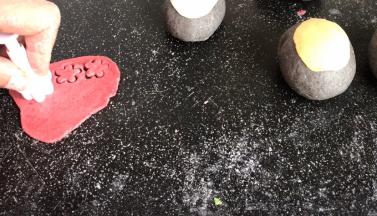 取红色面团，用花模切出小花朵