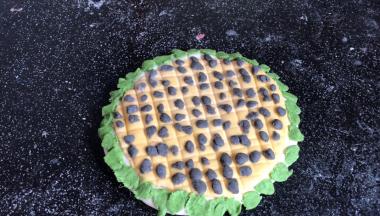 把绿色面团揪成小指尖大小的面片，粘在白边上