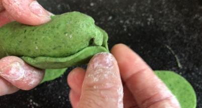 再用3片没有邦的叶子，一片叠压一片的包住白菜心，把顶部折成白菜包裹的样子